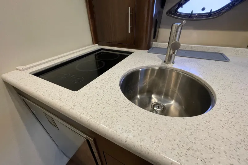 Slide: The Image of 2017 Regal 35 Sport Coupe kitchen with sink and induction cooktop. - 30