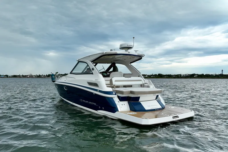 Slide: The Image of 2017 Regal 35 Sport Coupe boat on water under cloudy sky. - 7