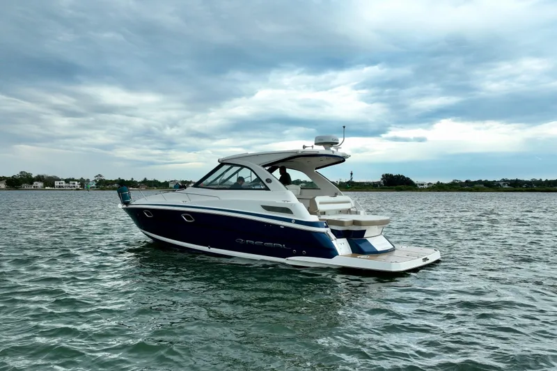Slide: The Image of 2017 Regal 35 Sport Coupe boat on calm water under cloudy sky. - 8