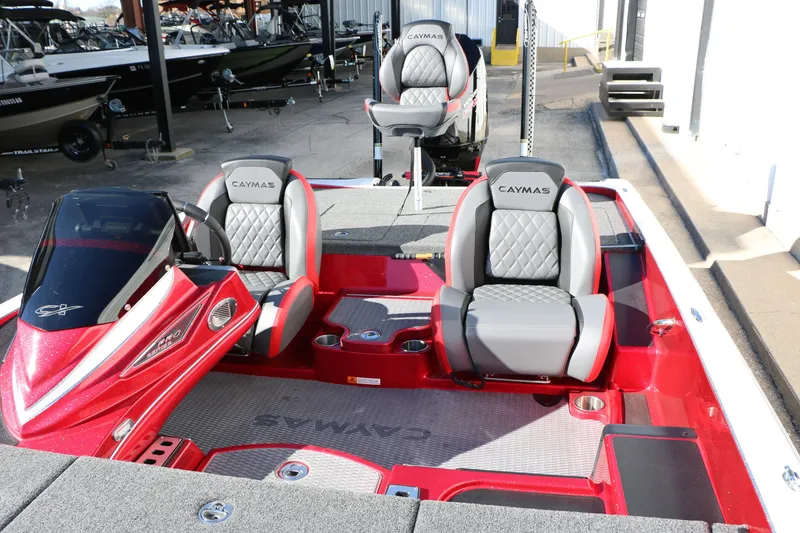 Slide: The Image of 2025 Caymas CX 20 PRO boat interior with red and gray seating, docked at marina. - 30