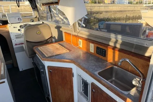 Slide: The Image of 2007 ACB Sportfisher boat interior with kitchenette, sink, and seating area. - 19