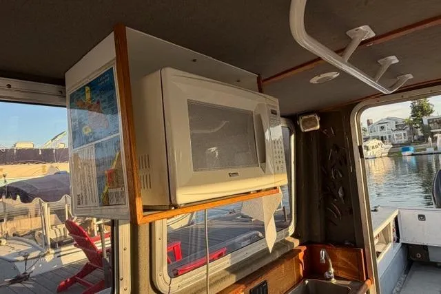 Slide: The Image of 2007 ACB Sportfisher boat interior with microwave and dockside view. - 23