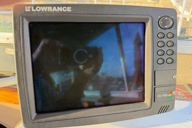 Slide: The Image of Lowrance fishfinder on 2007 ACB Sportfisher boat dashboard, reflecting surroundings. - 24