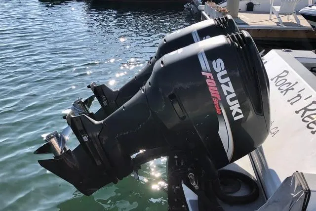 Slide: The Image of Twin Suzuki outboard motors on a 2007 ACB Sportfisher boat, docked by the water. - 25