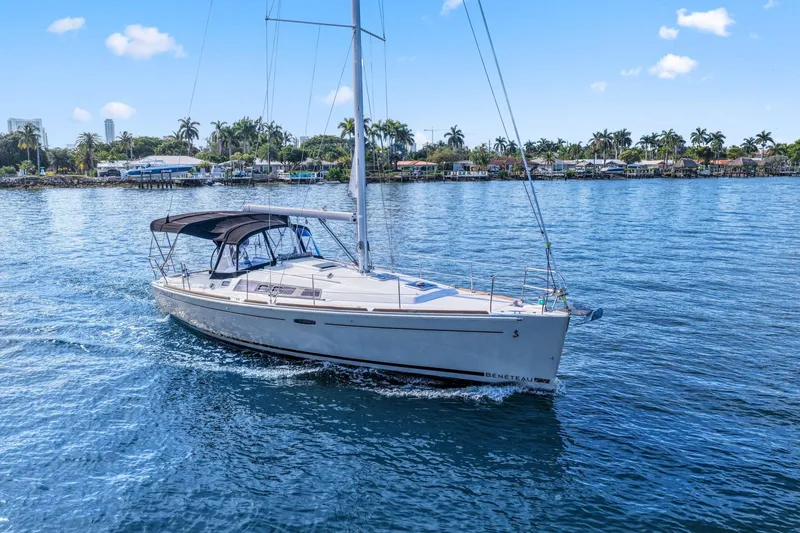 Slide: The Image of 2014 Beneteau Oceanis 37 sailboat cruising on a sunny day, surrounded by palm trees. - 11