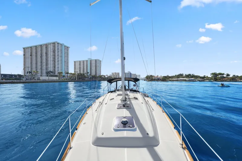 Slide: The Image of 2014 Beneteau Oceanis 37 sailing in a coastal city with skyscrapers in the background. - 14