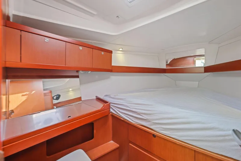 Slide: The Image of Cozy cabin interior of 2014 Beneteau Oceanis 37 with wooden cabinetry and comfortable bedding. - 22