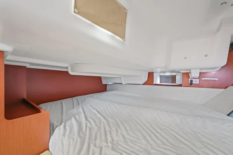 Slide: The Image of Interior cabin of 2014 Beneteau Oceanis 37 sailboat, featuring a cozy bed and wooden accents. - 27