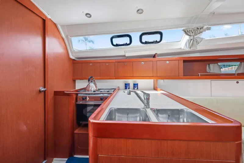 Slide: The Image of Interior of 2014 Beneteau Oceanis 37 yacht kitchen with wood cabinetry and dual sinks. - 30