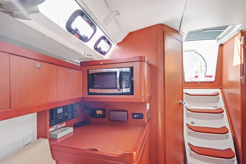 Slide: The Image of Interior of 2014 Beneteau Oceanis 37 yacht with wooden cabinetry and microwave. - 36