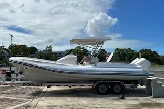 Slide: The Image of 2022 Zar Formenti 85 boat on trailer, parked outdoors under cloudy sky. - 13