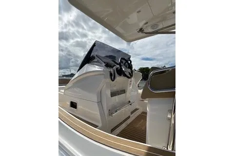 Slide: The Image of 2022 Zar Formenti 85 boat interior with steering wheel and dashboard under cloudy sky. - 16