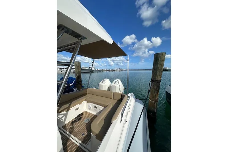 Slide: The Image of 2022 Zar Formenti 85 boat docked, featuring seating area and canopy under blue sky. - 9