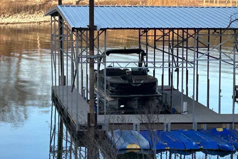 Slide: The Image of Covered dock with 2020 Avalon 2785 Excaliber boat on calm river. - 2