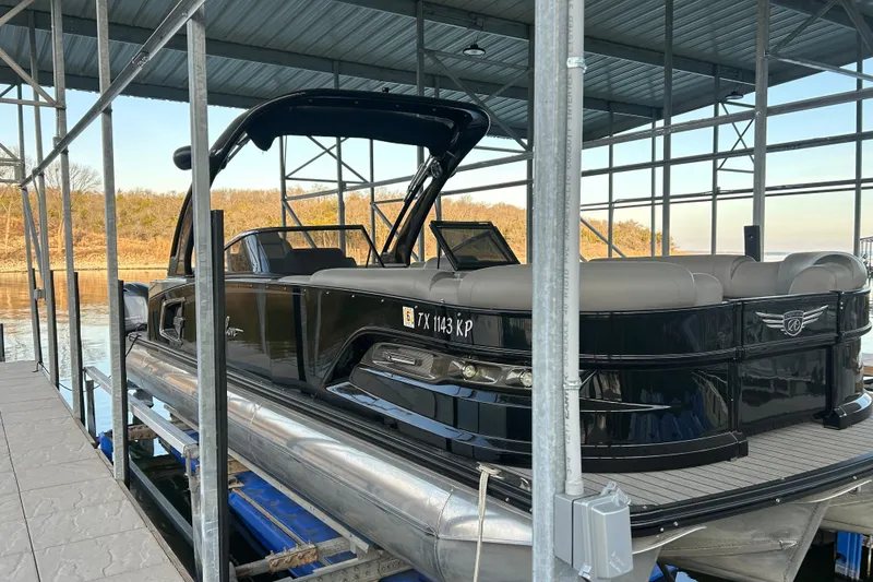 Slide: The Image of 2020 Avalon 2785 Excaliber pontoon boat docked under a metal canopy. - 4