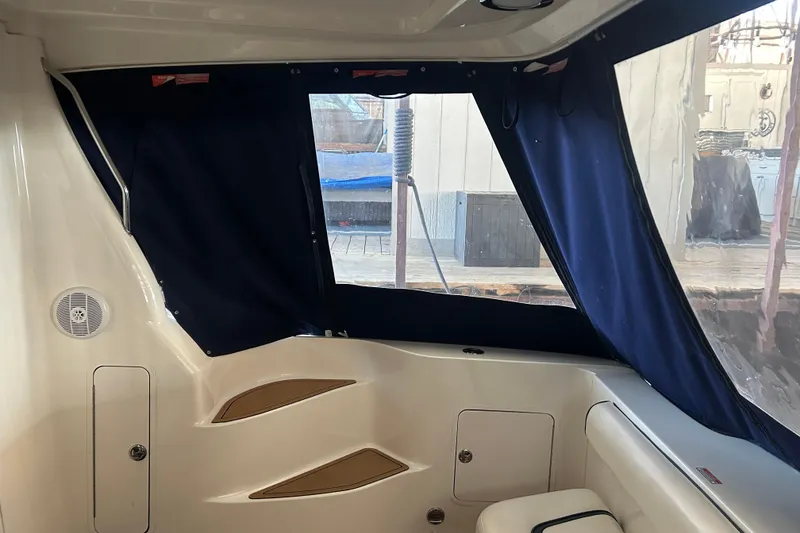 Slide: The Image of 2005 Sea Ray 44 Sedan Bridge interior with blue curtains and seating area. - 26