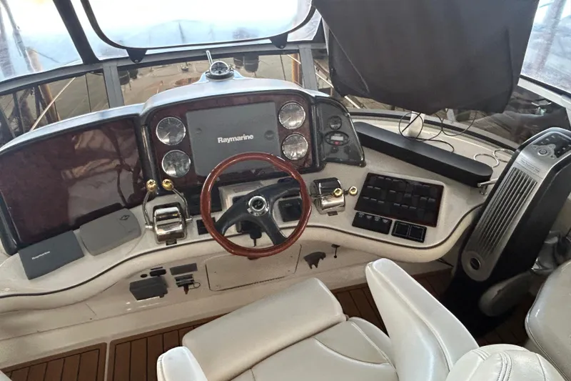 Slide: The Image of 2005 Sea Ray 44 Sedan Bridge helm with Raymarine electronics and wooden steering wheel. - 31