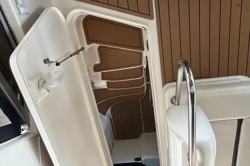 Slide: The Image of 2005 Sea Ray 44 Sedan Bridge interior with wooden flooring and white seating. - 32