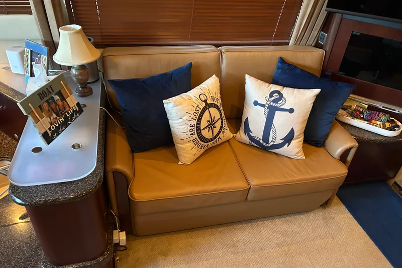 Slide: The Image of Luxurious 2005 Sea Ray 44 Sedan Bridge interior with nautical-themed cushions on a leather sofa. - 37