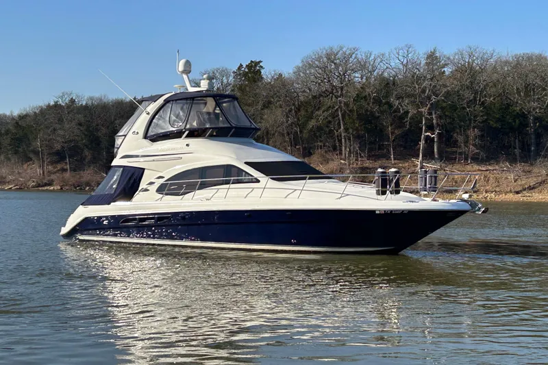 Slide: The Image of 2005 Sea Ray 44 Sedan Bridge yacht on calm water, surrounded by trees. - 47