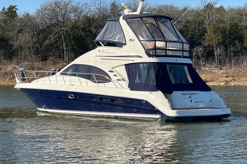 Slide: The Image of 2005 Sea Ray 44 Sedan Bridge yacht cruising on a calm lake. - 52