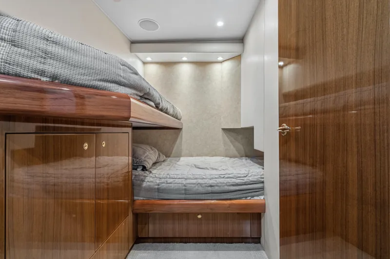 Slide: The Image of 2007 Viking 56 Convertible yacht cabin with bunk beds and wooden cabinetry. - 19