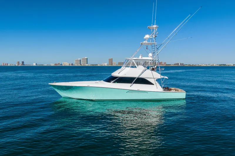 Slide: The Image of 2007 Viking 56 Convertible yacht on calm blue ocean with city skyline in background. - 2