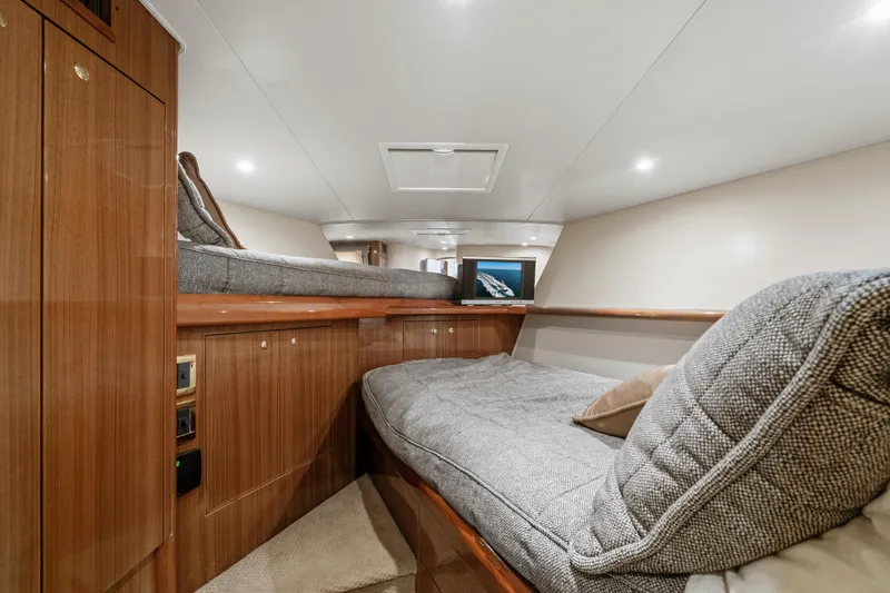 Slide: The Image of Luxurious interior of 2007 Viking 56 Convertible yacht with cozy bedding and wood finish. - 27