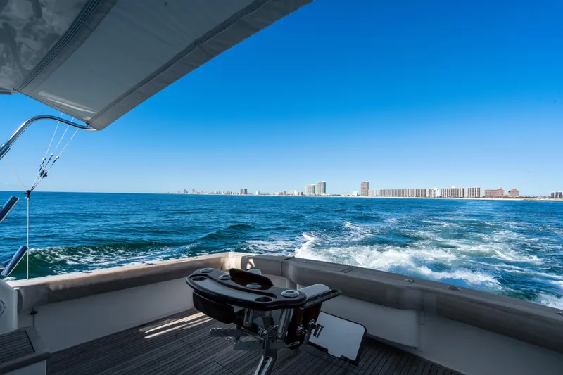 Slide: The Image of 2007 Viking 56 Convertible yacht cruising with city skyline in the background. - 33