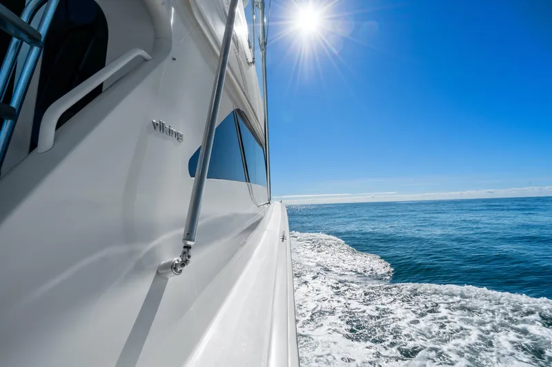 Slide: The Image of 2007 Viking 56 Convertible yacht cruising under bright sun on open sea. - 36