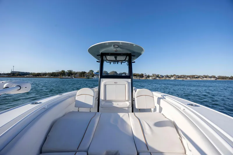Slide: The Image of 2021 Sea Hunt Ultra 265 SE boat on calm water, clear sky background. - 13