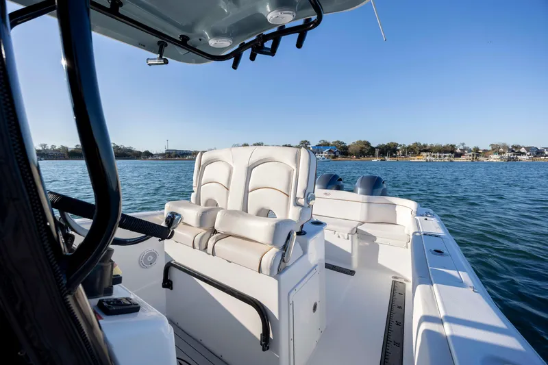 Slide: The Image of 2021 Sea Hunt Ultra 265 SE boat interior with seating, on calm water. - 14