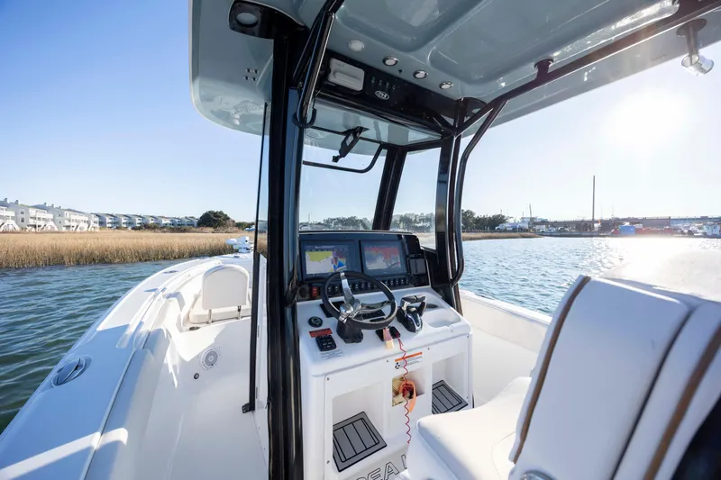 Slide: The Image of 2021 Sea Hunt Ultra 265 SE boat interior with navigation system on a sunny day. - 15