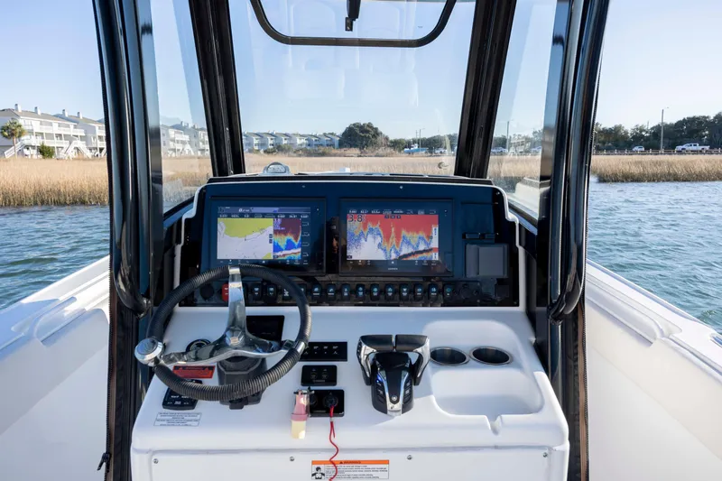 Slide: The Image of 2021 Sea Hunt Ultra 265 SE boat dashboard with navigation screens and steering wheel. - 16