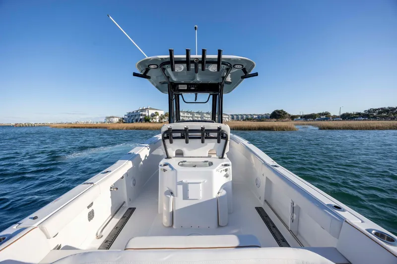 Slide: The Image of 2021 Sea Hunt Ultra 265 SE boat on water, clear sky, coastal view. - 19