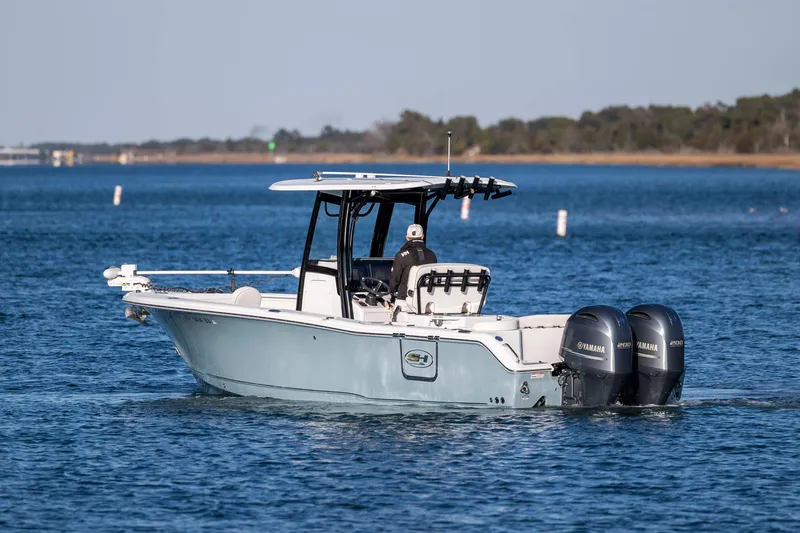 Slide: The Image of 2021 Sea Hunt Ultra 265 SE boat on calm water with dual Yamaha engines. - 4