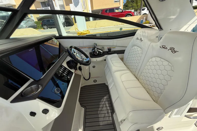 Slide: The Image of 2022 Sea Ray Sundancer 320 Outboard cockpit with luxurious white seating and modern controls. - 22