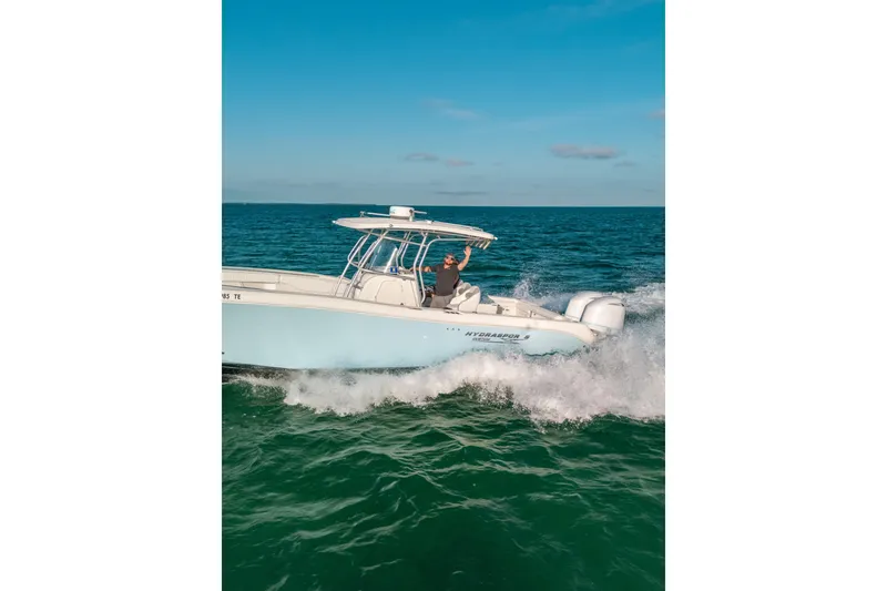 Slide: The Image of 2005 Hydra-Sports 3300 CC boat cruising on open water under clear blue skies. - 11