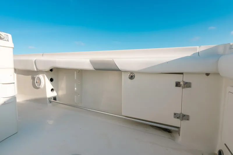 Slide: The Image of 2005 Hydra-Sports 3300 CC boat interior with storage compartment and speaker, under clear blue sky. - 23