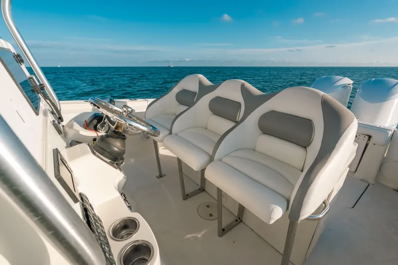 Slide: The Image of 2005 Hydra-Sports 3300 CC boat interior with steering wheel and cushioned seats on open water. - 26