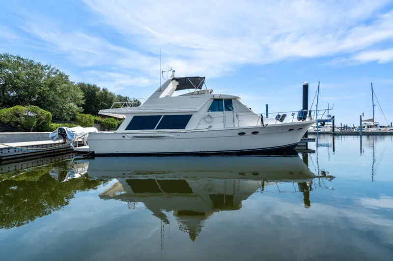 Slide: The Image of 2007 Meridian 490 Pilothouse yacht docked in a serene marina setting. - 52