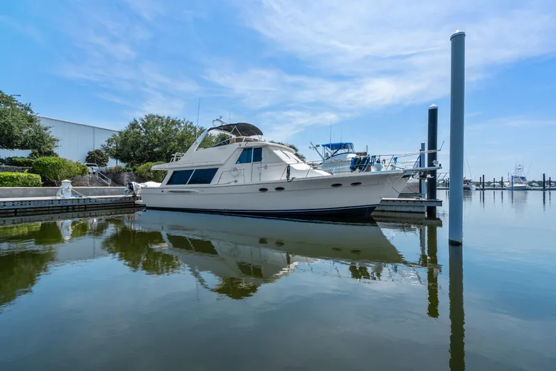 Slide: The Image of 2007 Meridian 490 Pilothouse yacht docked in a serene marina setting. - 54