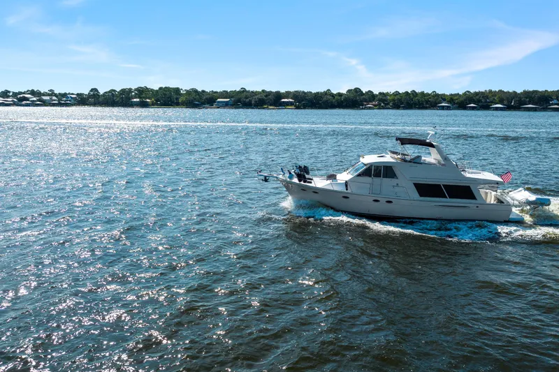 Slide: The Image of 2007 Meridian 490 Pilothouse yacht cruising on a sunny day, with scenic shoreline backdrop. - 7
