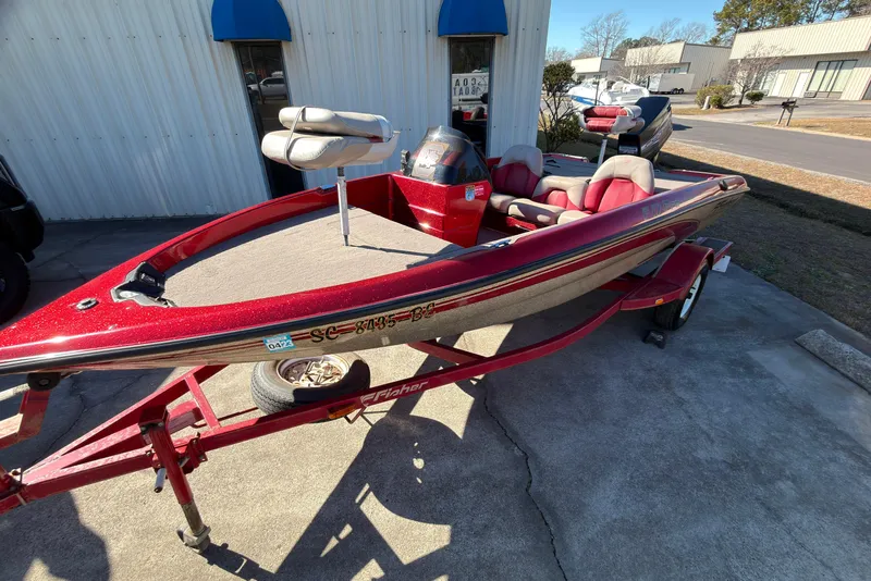 The Image of Red 1998 Fisher F 17 Pro boat on trailer, parked outside a building. - 0