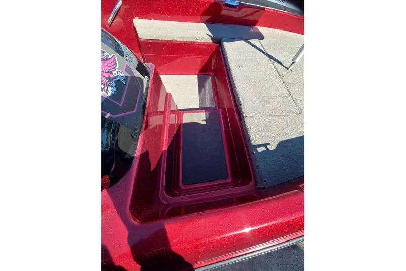 Slide: The Image of Red 1998 Fisher F 17 Pro boat interior with carpeted deck and storage compartment. - 10
