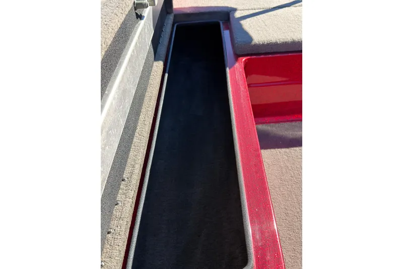 Slide: The Image of 1998 Fisher F 17 Pro boat storage compartment with red and gray interior. - 13