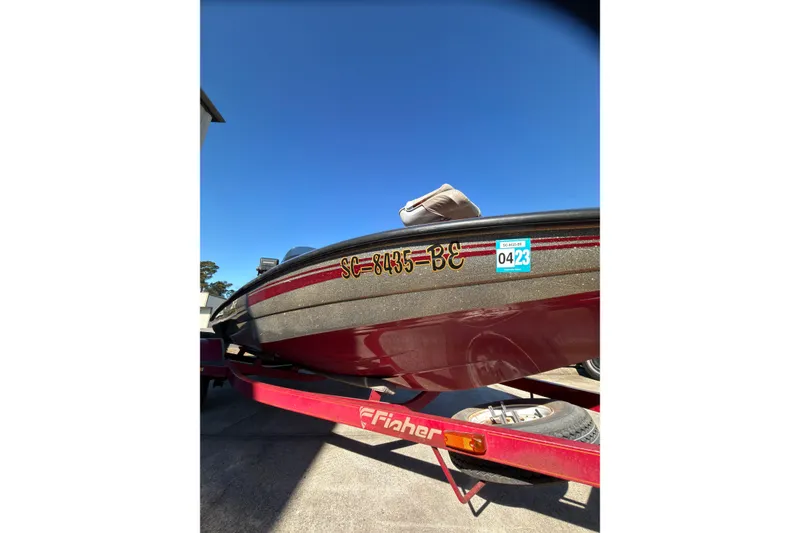 Slide: The Image of 1998 Fisher F 17 Pro boat on trailer, registration SC-8435-BE, under clear blue sky. - 17