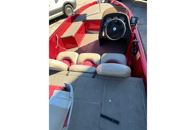 Slide: The Image of 1998 Fisher F 17 Pro boat interior with red and gray seating, steering wheel, and dashboard. - 18