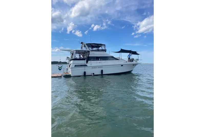 The Image of 1989 Silverton 46 Aft Cabin yacht on calm water under a blue sky. - 0