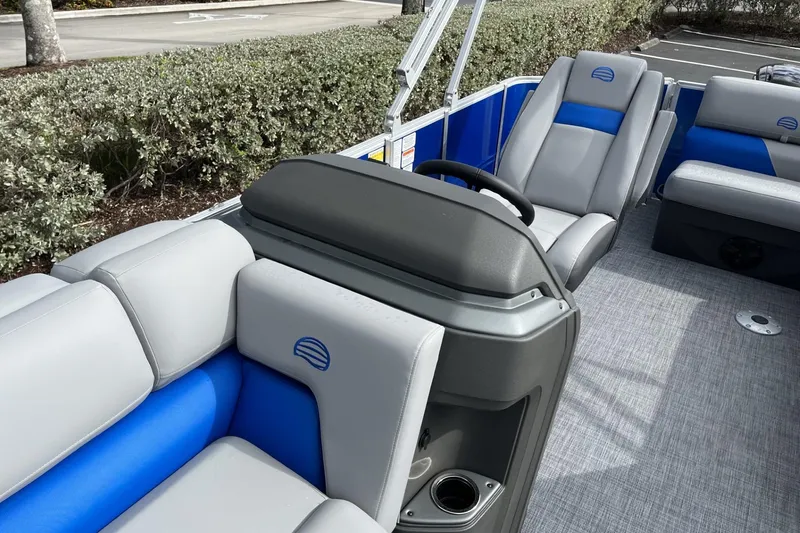 Slide: The Image of 2026 Sun Tracker Party Barge 20 DLX interior with gray and blue seating, steering console. - 102